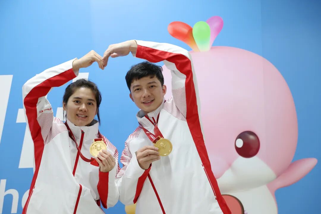 黄梦萍(左)和罗振邦“比心”并展示金牌。