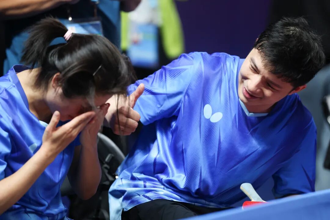 黄梦萍在夺冠后激动落泪,罗振邦在一旁为她竖起大拇指。