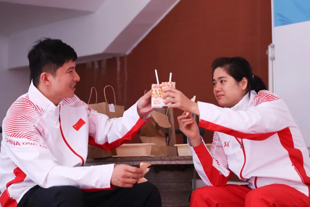 黄梦萍(右)和罗振邦在吃午餐时“干杯”庆祝夺冠。