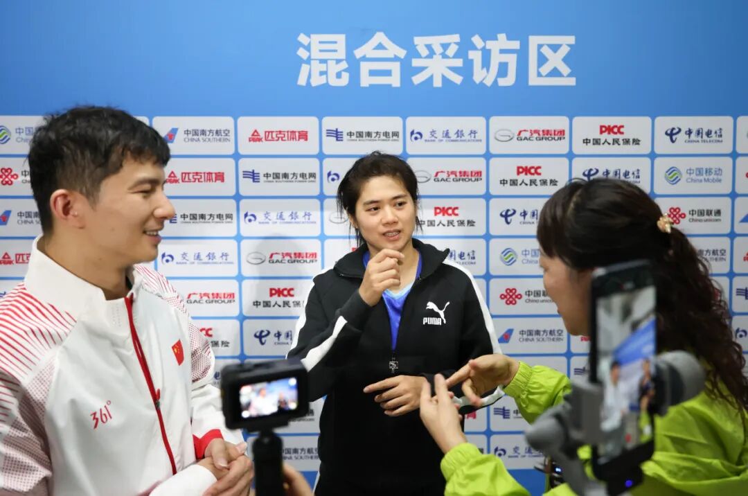 黄梦萍(中)和罗振邦(左)通过手语回应媒体采访。